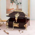 a dark rosewood aamada petti jewellery box surrounded by gold jewellery with pearls in the main container