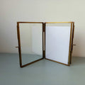 Standing double photo frame with a golden finish. Displayed in portrait
